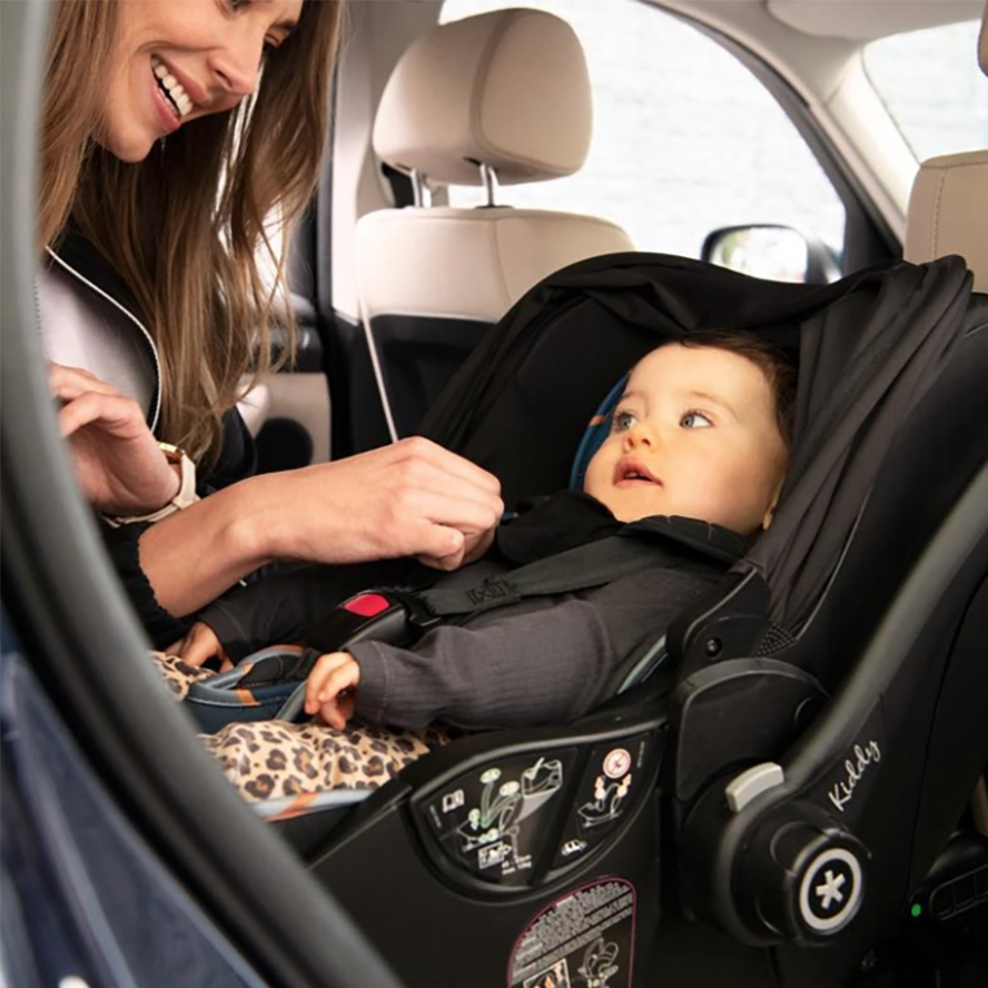 a happy baby in a car seat