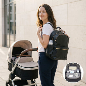 A woman wearing a baby black changing backpack with gold zipper accents stands next to a stroller, with an inset circle showing the backpack's interior storage layout.