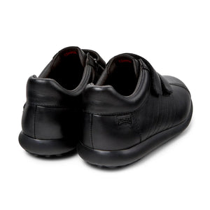 Rear view of Camper Pelotas black leather shoes for kids, showing the padded heel and the Camper logo embossed on the side.
