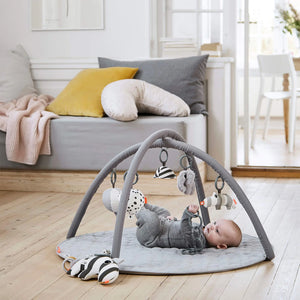 A baby is playing with the hanging toy.