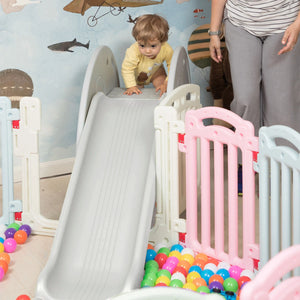 A happy toddler sliding down the elephant slide with a big smile.