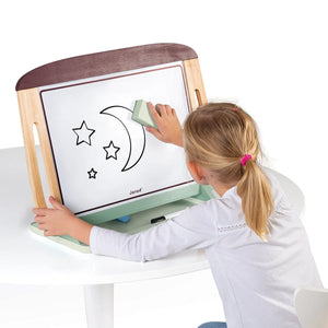 Child using the portable Janod white and blackboard table with built-in handles