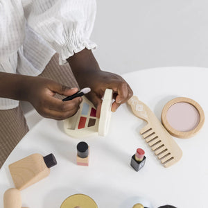 A child is playing with the Le Toy Van toy cosmetic set.