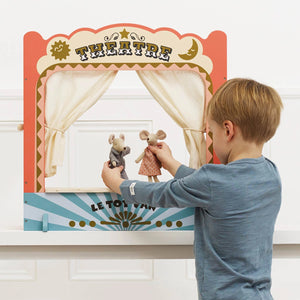 A boy is playing in a toy theatre with mice doll.