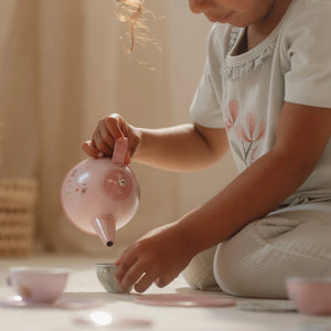 A girl is playing with the Little Dutch tea set.