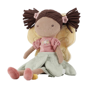 Little Dutch Fairy Evi doll in a pink dress sitting in a fairy garden.
