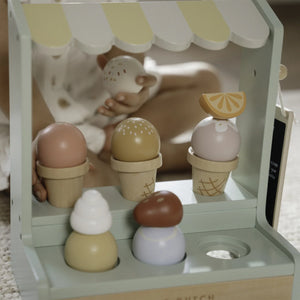 A girl is playing with the ice cream cart