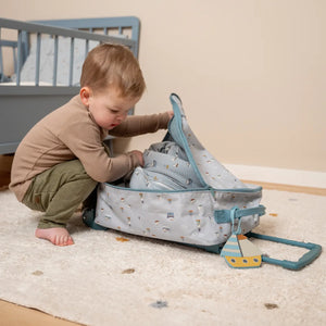 Toddler suitcase next to travel essentials, showcasing its compact yet roomy design.