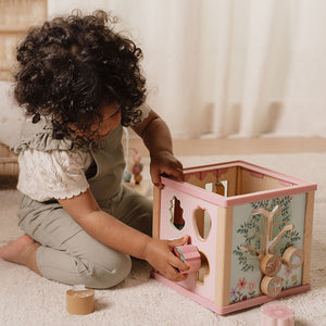 Toddler using Little Dutch wooden activity cube to play and learn