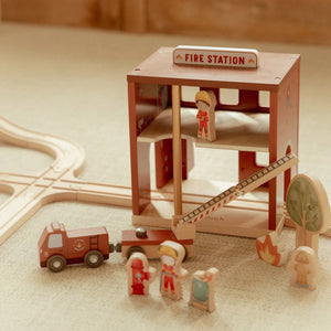 Wooden toy firefighters sliding down the pole in fire station