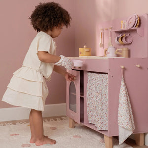 Child playing with little dutch wooden play kitchen pink.