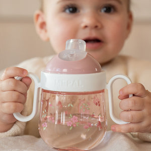 Close-up of a baby holding the BPA-free Little Dutch antileak spout cup, demonstrating the mess-free drinking design for small hands.