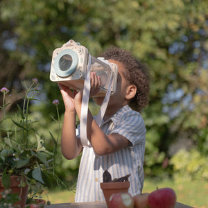 Kids observing insects outdoors with magnifying glass