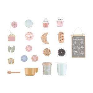 A flat lay layout on a white background displaying all the individual accessories included in the set, such as wooden donuts, croissants, coffee pods, cups, spoons, tea bags, and a menu board.