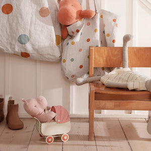 A beautifully designed miniature pram in coral colour, perfect for dolls and teddy babies.