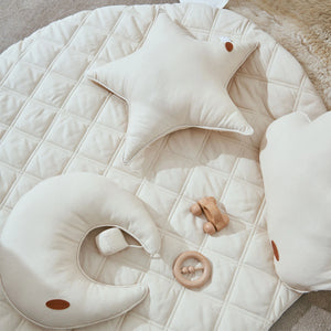 A close-up of a quilted play mat with a variety of textures and plush toys sewn on.