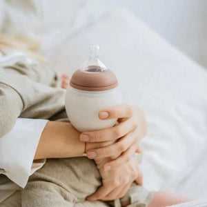 Mother holding feeding bottle with milk elhee 240ml 80oz blossom
