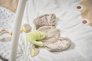 Plush toy resembling a cat with floral pattern on a textured surface