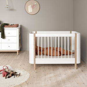 Compact baby cot with adjustable base and removable bars