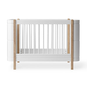 Wood Mini+ cot bed in white and oak with a clean Scandinavian design