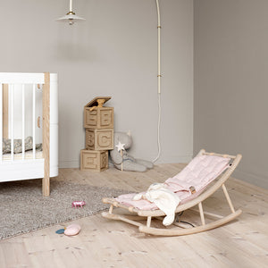 Minimalist Scandinavian baby rocker shown in a bright nursery setting