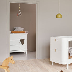 Wide shot of full nursery furniture set with matching wooden tones