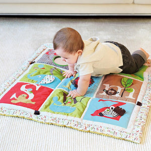 Soft padded baby activity mat with developmental play features