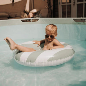 A kid is having fun with the swim ring in the pool.