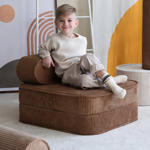 A boy is smiling and sitting on the foldable chair – Lifestyle Image
