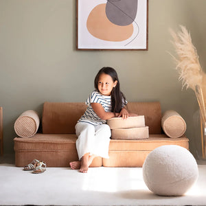 A girl is sitting on the modular sofa set.