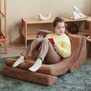 A toddler is sitting on the moon-shaped chair.