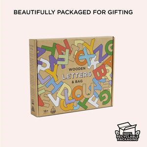Box of wooden letters with colorful design on a beige background
