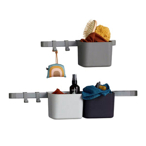 A Leander Baby organiser box Duo Rack with two woven storage baskets. The rack is mounted on a white wall and is above a changing table.