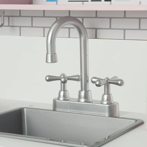 A brushed silver double-handle play kitchen faucet with a high-arc spout, installed in a stainless steel sink against a white subway tile backsplash.