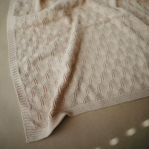 Breathable, neutral-toned organic cotton blanket.