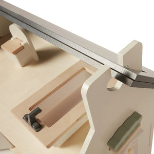 This picture provides a close-up view of the dollhouse loft. The window and door with a latch on the top floor are what draw the eye.