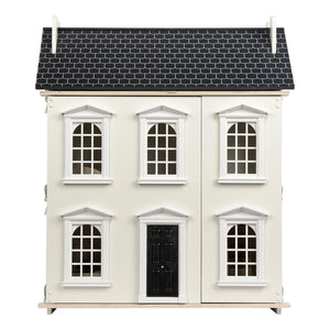 It is a classic-style modern dollhouse, featuring a white facade and a black roof. The dollhouse features three stories with multiple windows and a black front door. Detailed shingles adorn the roof.