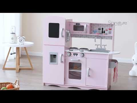 Video featuring a parent discussing their positive experience with the Deluxe Pink Wooden Play Kitchen. They highlight ease of assembly and their child's long-term enjoyment of the toy while scenes of the child playing are shown.