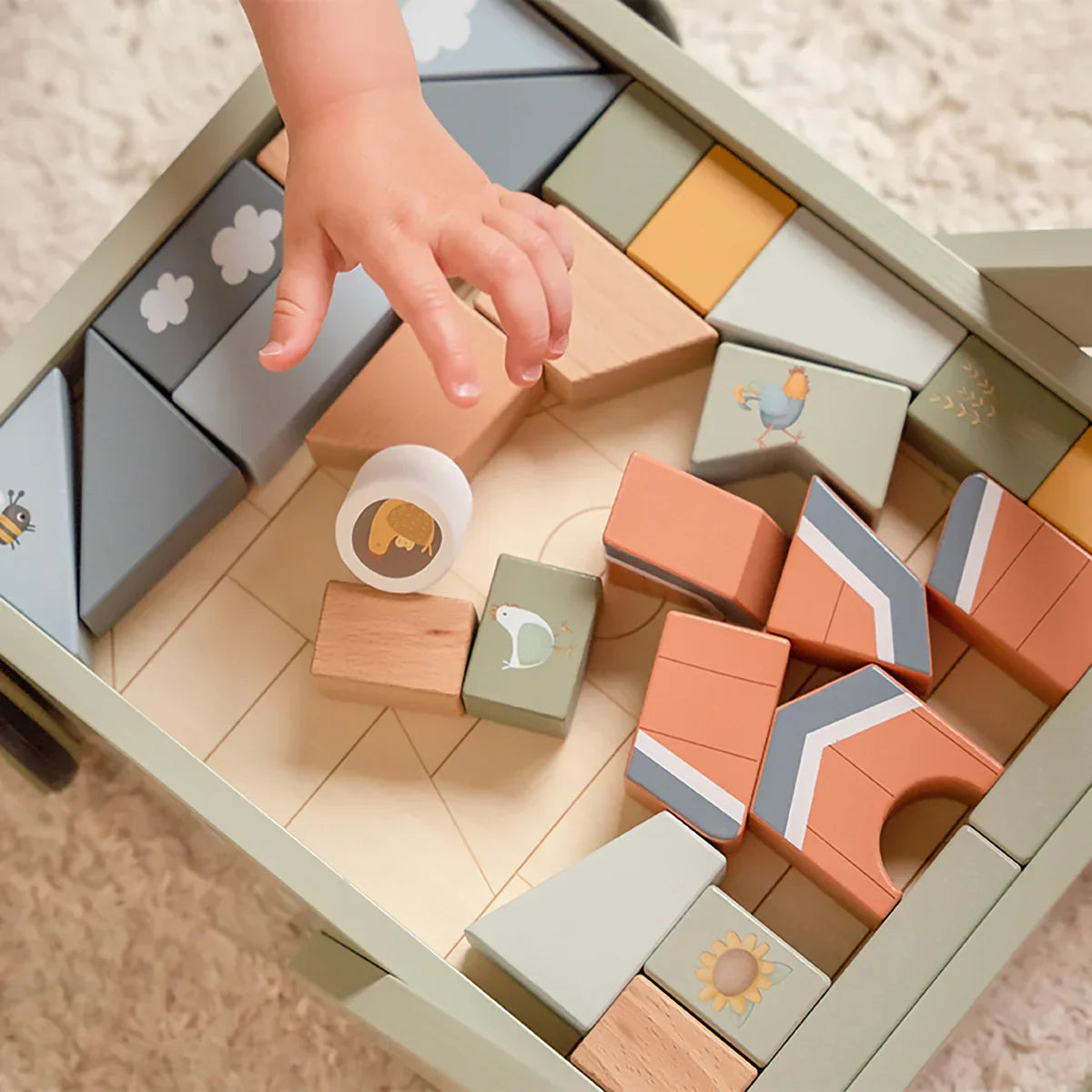 A baby is playing with little dutch wooden toys.