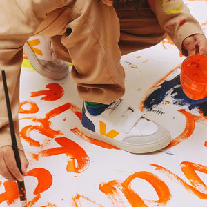 Child wearing Veja white sneakers, active outdoor play