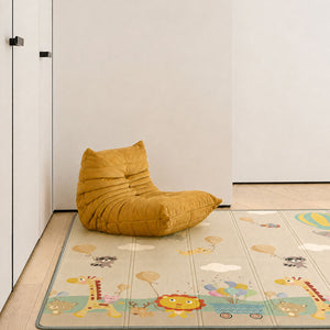 A mustard yellow crescent-shaped bean bag chair sits on a light beige children's play mat with cartoon animals and clouds, placed in a minimalist room corner with white walls and light wood flooring.