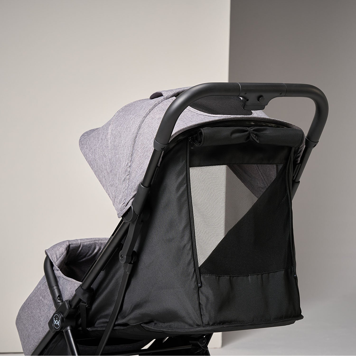 Black and grey baby stroller highlighting pop-up visor on a light grey background