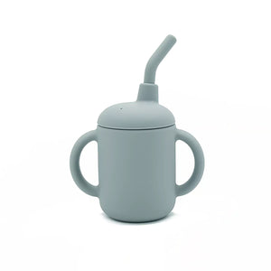 Front view of soft grey-blue silicone sippy cup with handles and built-in straw.