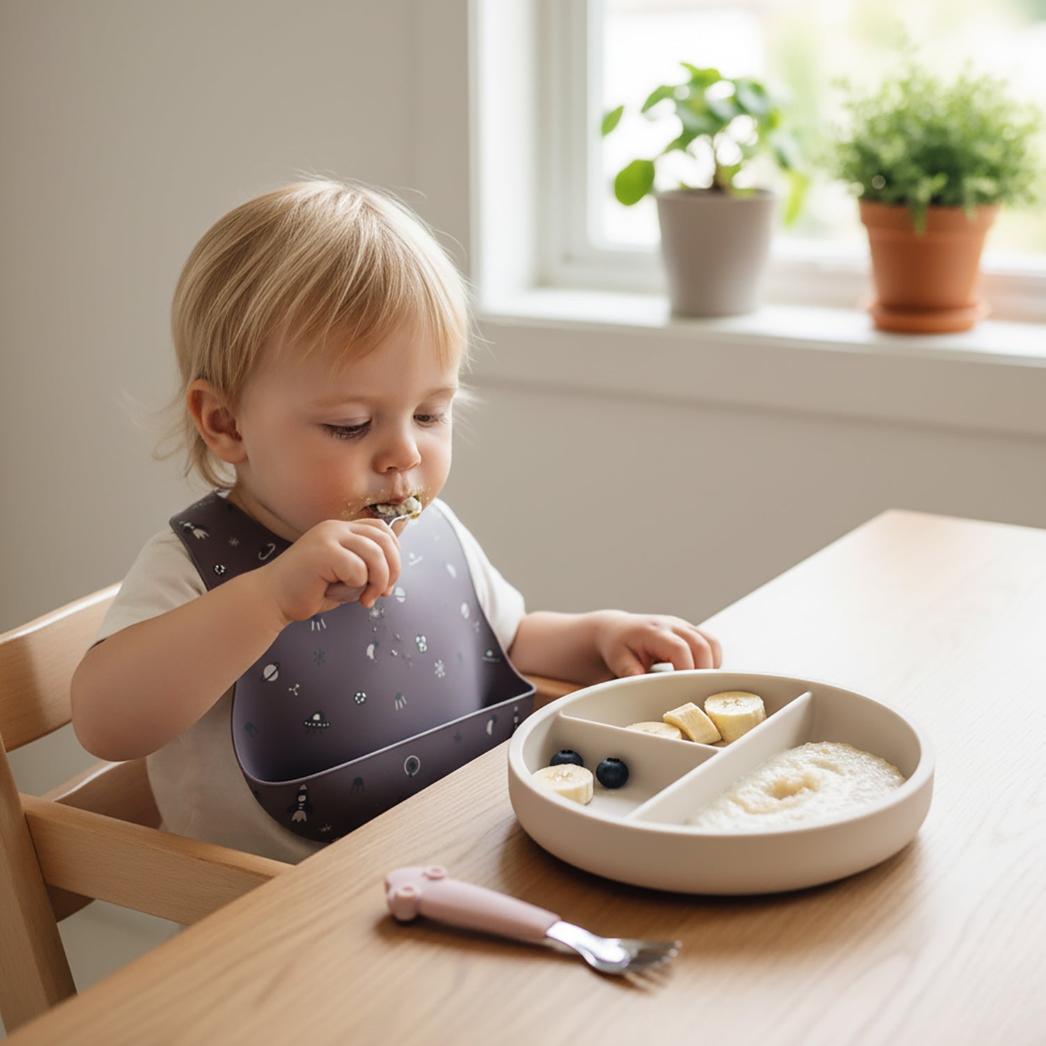 Baby learning to self-feed using Allis Baby fork and spoon set