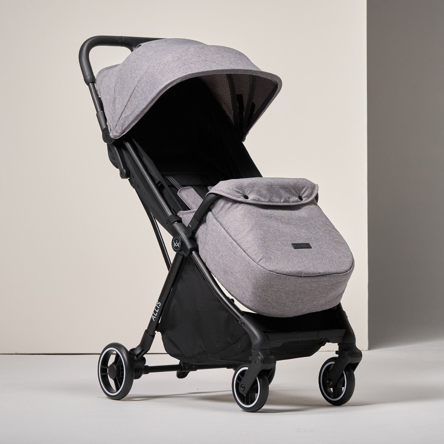 Gray and black stroller with folded bassinet on a light background