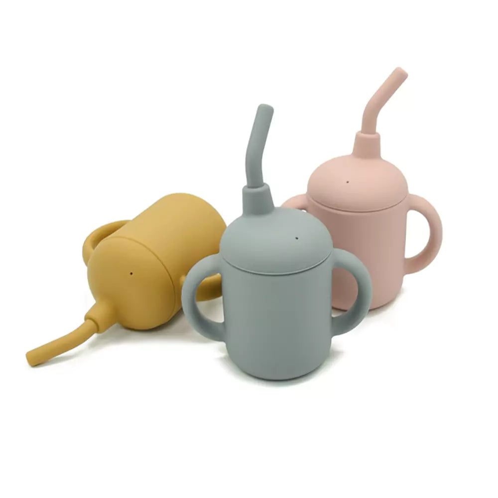Three Allis Baby silicone sippy cups with handles and straws in mustard yellow, grey-blue, and blush pink.