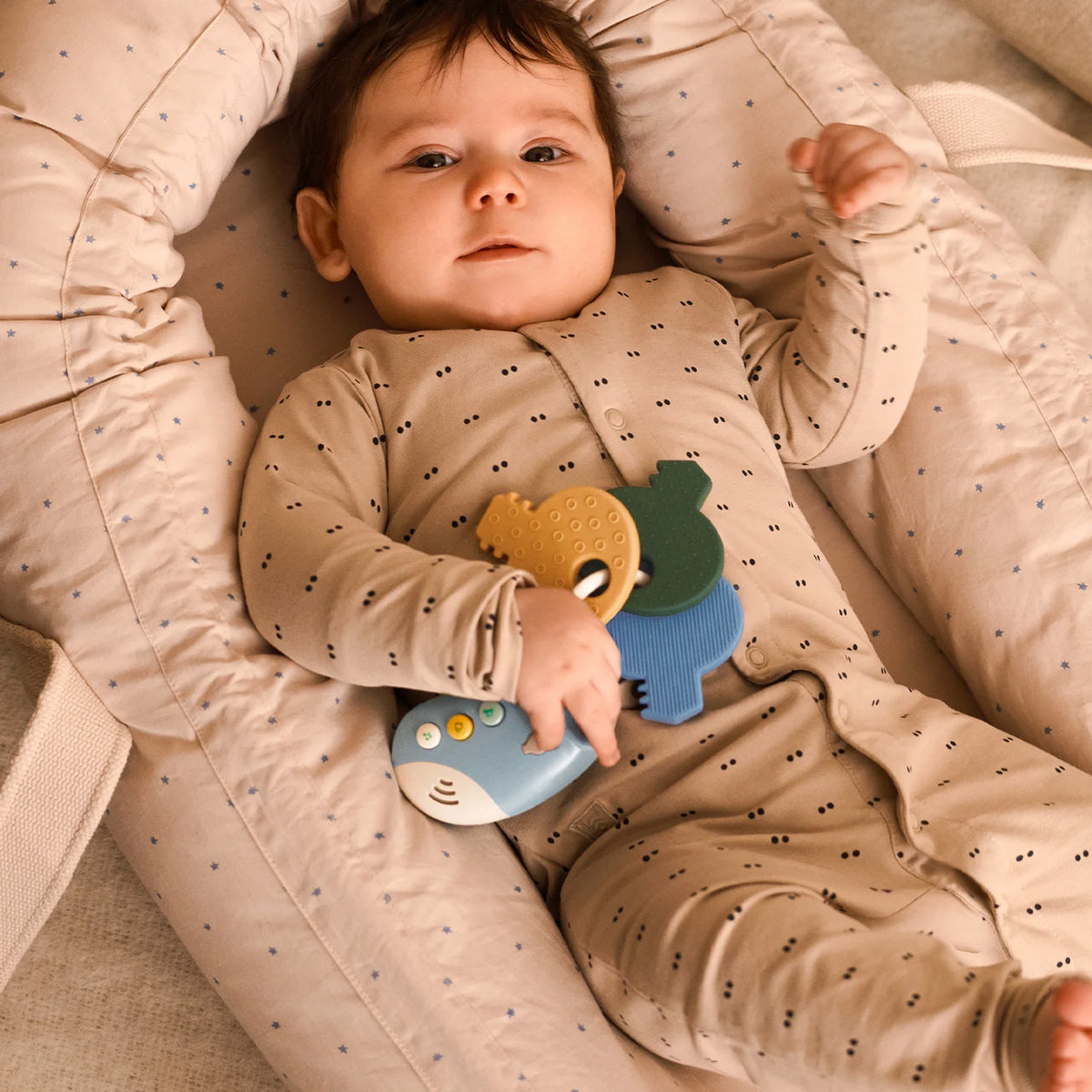 Baby sleeping comfortably inside Liewood Gro Baby Lift, cosy nest design