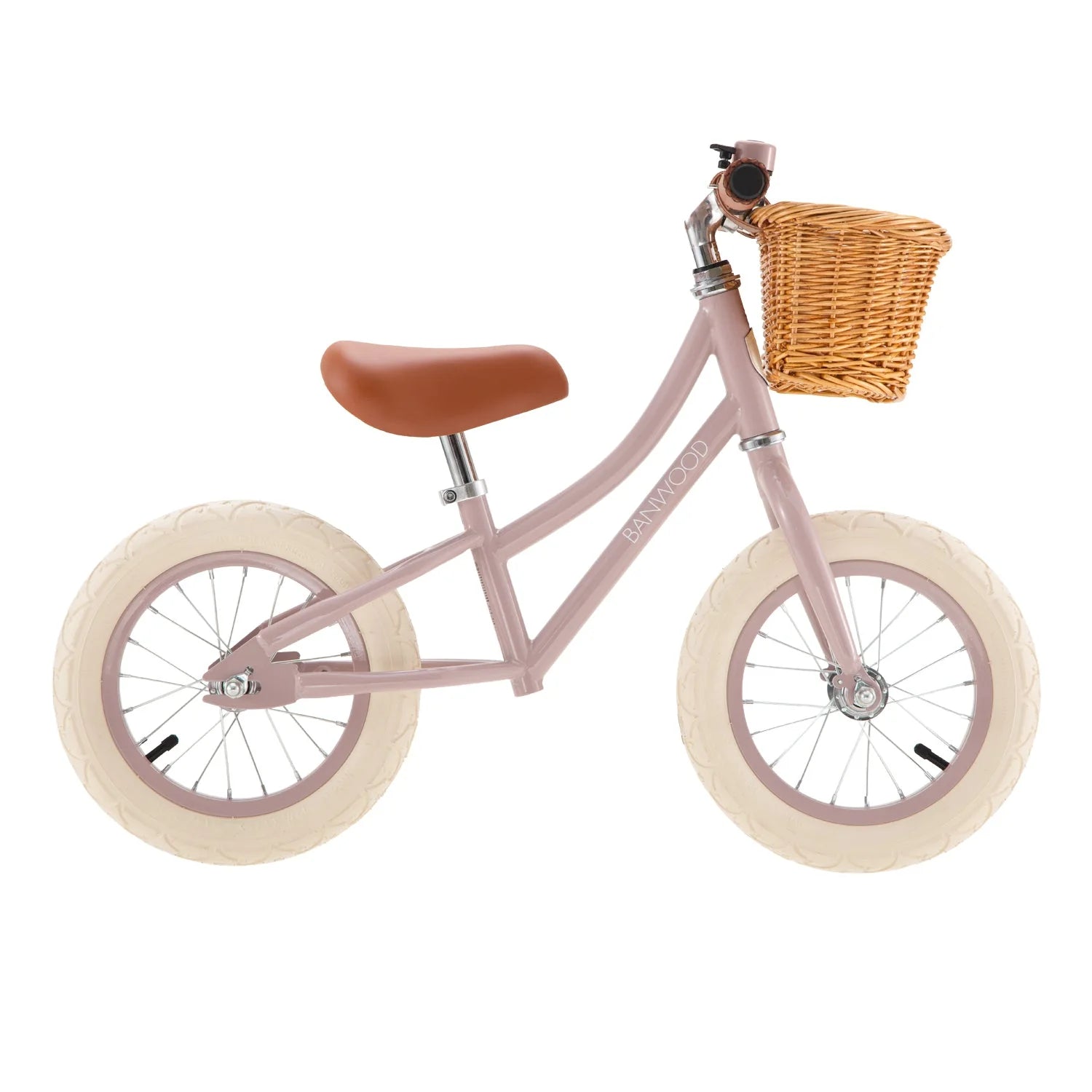 Dusty pink balance bike with a wicker basket on a white background