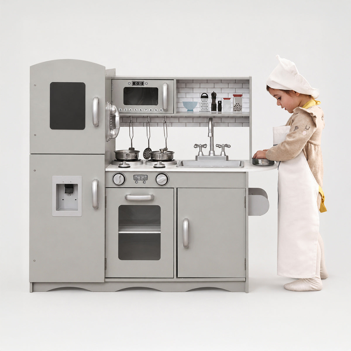 Young toddler playing with the deluxe grey wooden toy kitchen set.