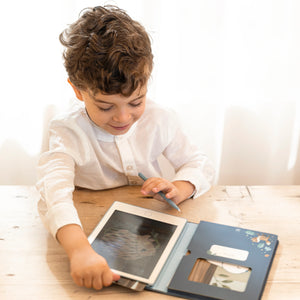 Young boy drawing on Little Dutch Blue Forest Friends tablet at table